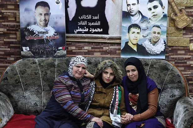 Asil al-Titi, a 23-year-old former prisoner (centre), pictured with her mum and sister