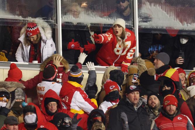 KANSAS CITY, MISSOURI - JANUARY 13: Taylor Swift celebrates with fans during the AFC Wild Card Playoffs between the Miami Dolphins and the Kansas City Chiefs at GEHA Field at Arrowhead Stadium on January 13, 2024 in Kansas City, Missouri. (Photo by Jamie Squire/Getty Images)