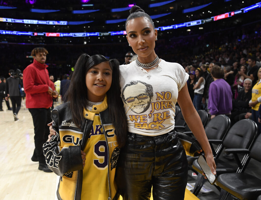 Kim Kardashian and North West see a sports game.