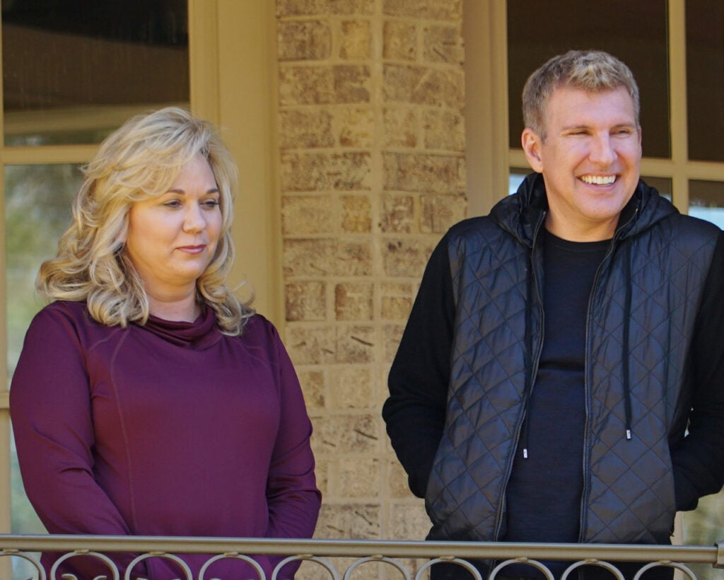 Julie Chrisley and Todd Chrisley stand outside.