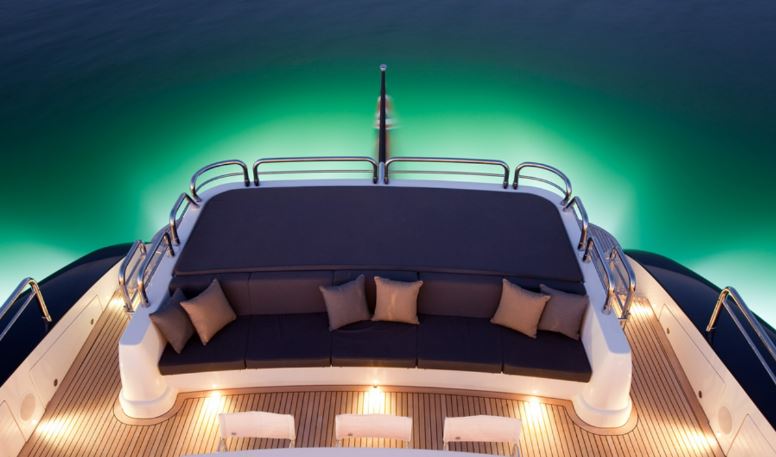 More outdoor seating surrounded by the illuminated sea from the yacht's underwater lights