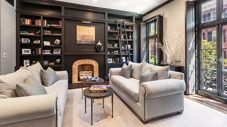 A living room with two couches and a bookshelf