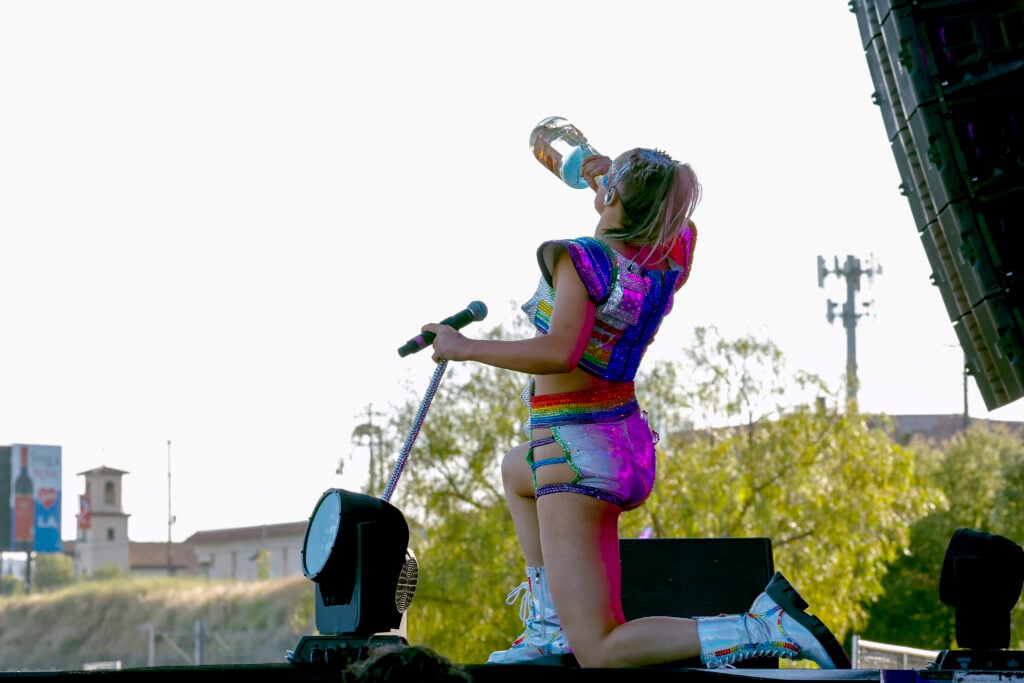 JoJo Siwa appears to chug her drink on stage at L.A. Pride in June of 2024.