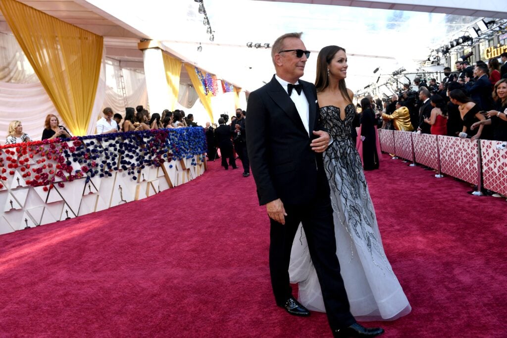 Kevin Costner and Christine Baumgartner walk the red carpet in late March of 2022.